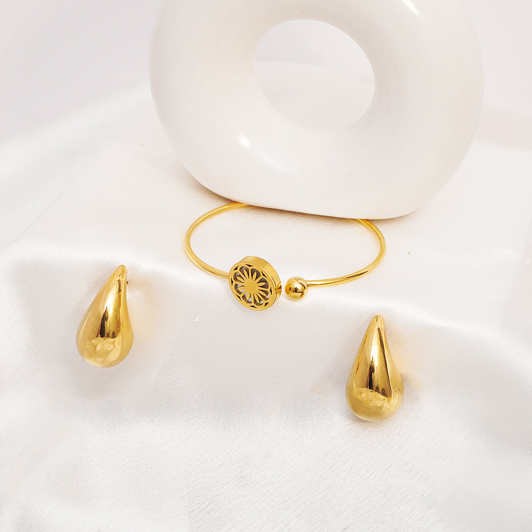 Gold bracelet with teardrop-shaped charms on a white background