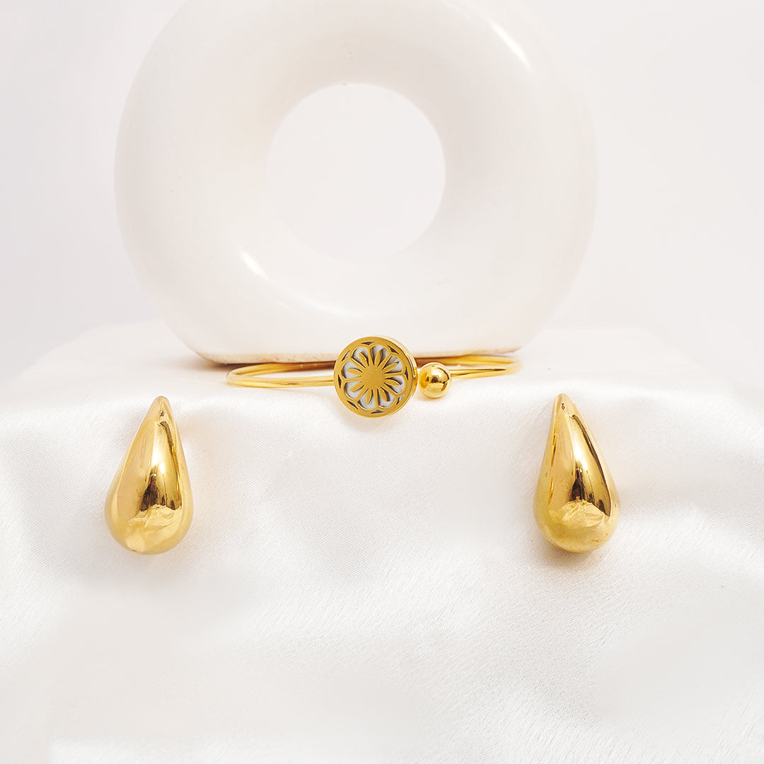 Gold teardrop earrings on a white heart-shaped background