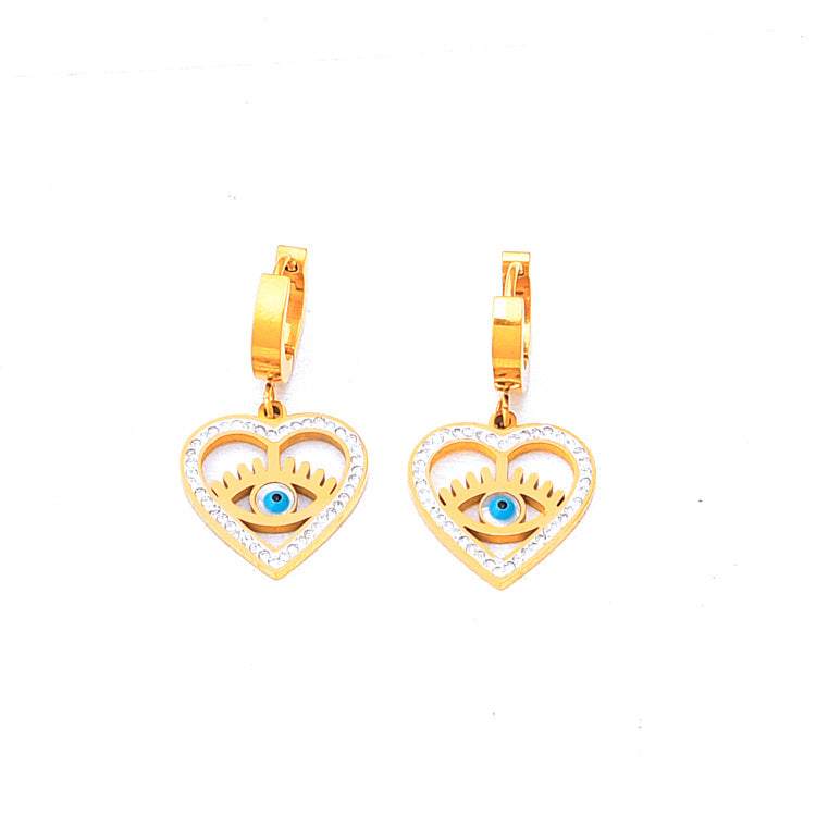 Gold heart-shaped earrings with eye design on a white background