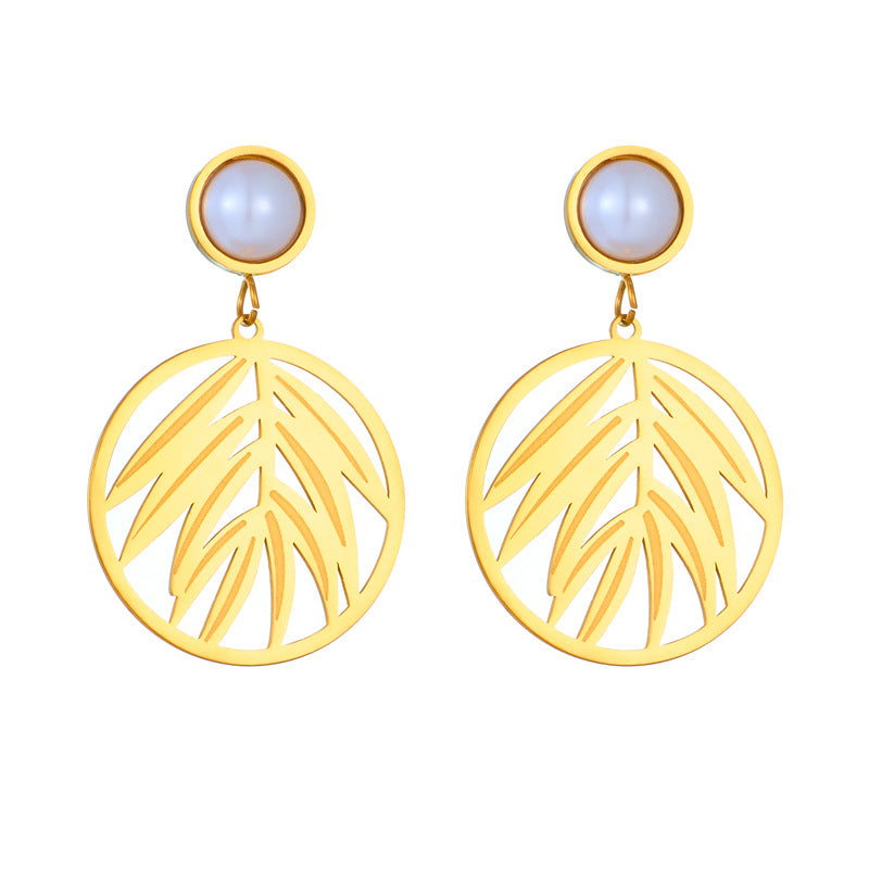 Gold leaf-shaped earrings with light blue gemstones on a white background