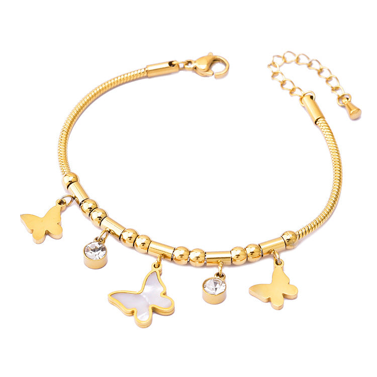 Gold bracelet with butterfly charms on a white background