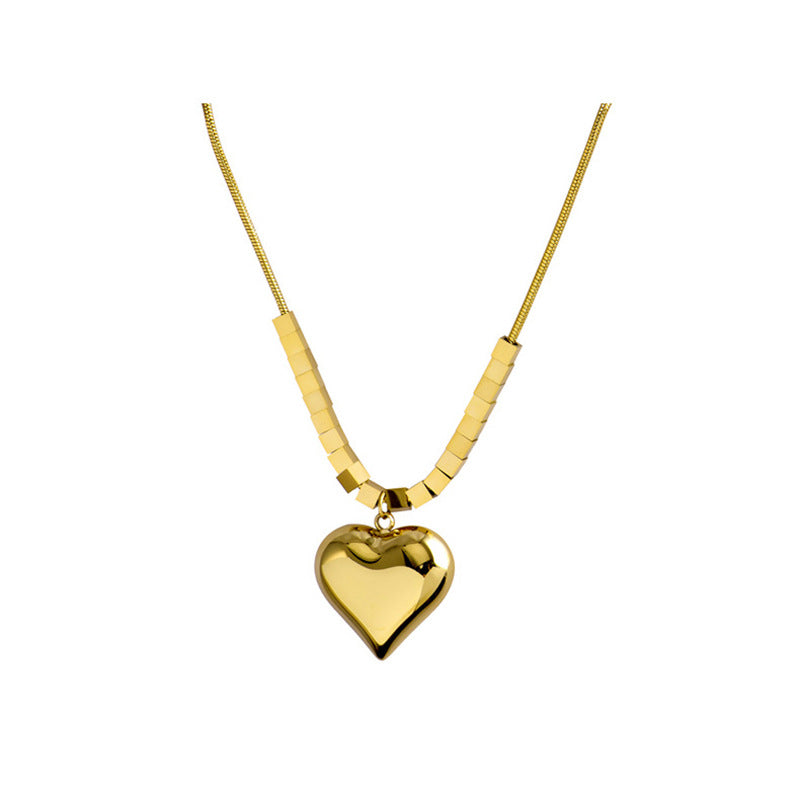 Gold heart-shaped pendant necklace on a white background