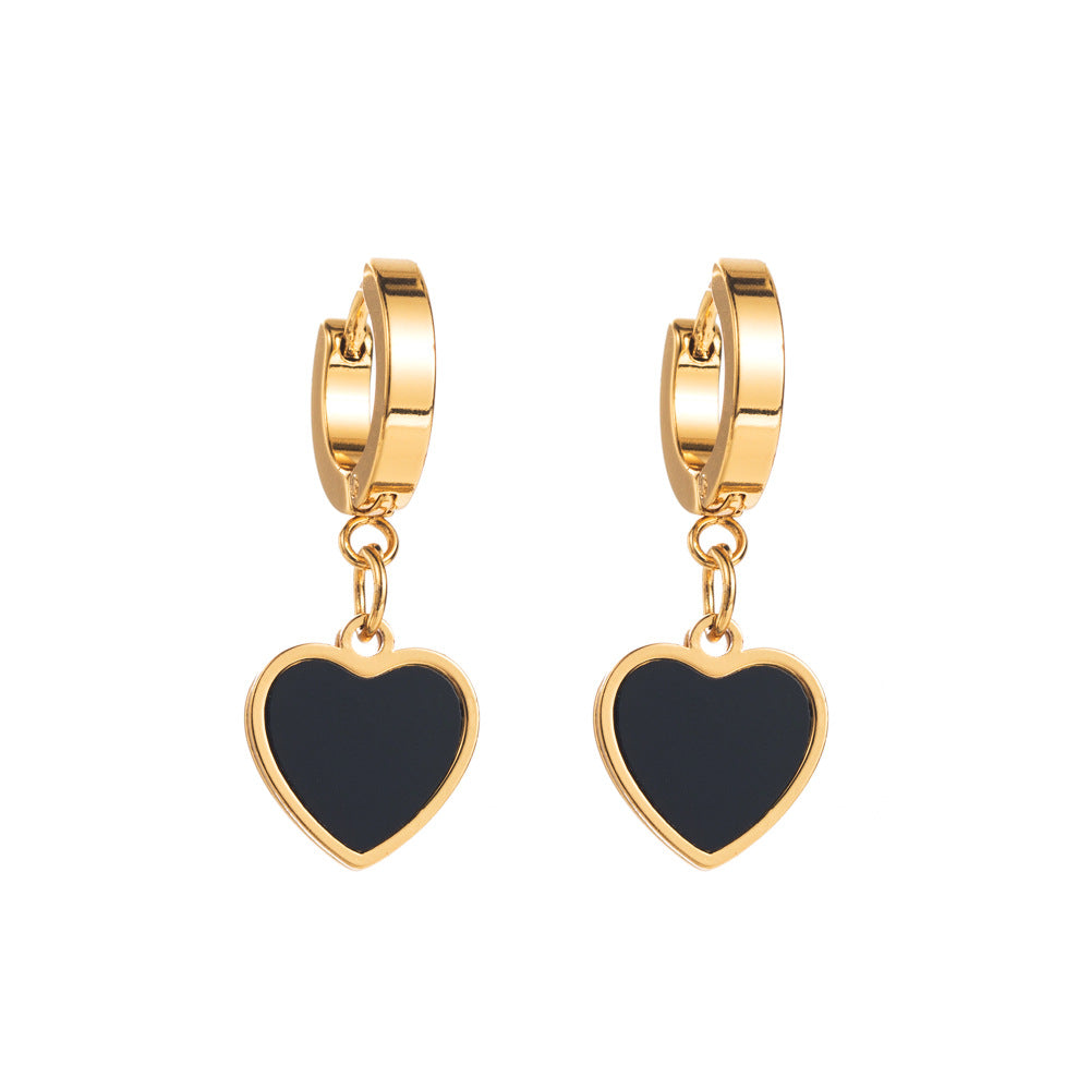 Gold hoop earrings with black heart charms on a white background