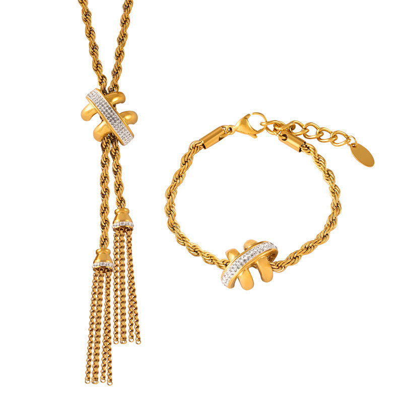 Gold jewelry set including necklace, bracelet, rings, and earrings on a stone surface.