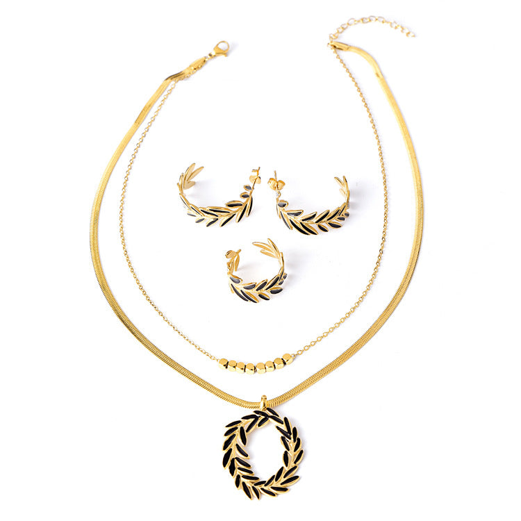 Gold necklace and earrings set on a white background
