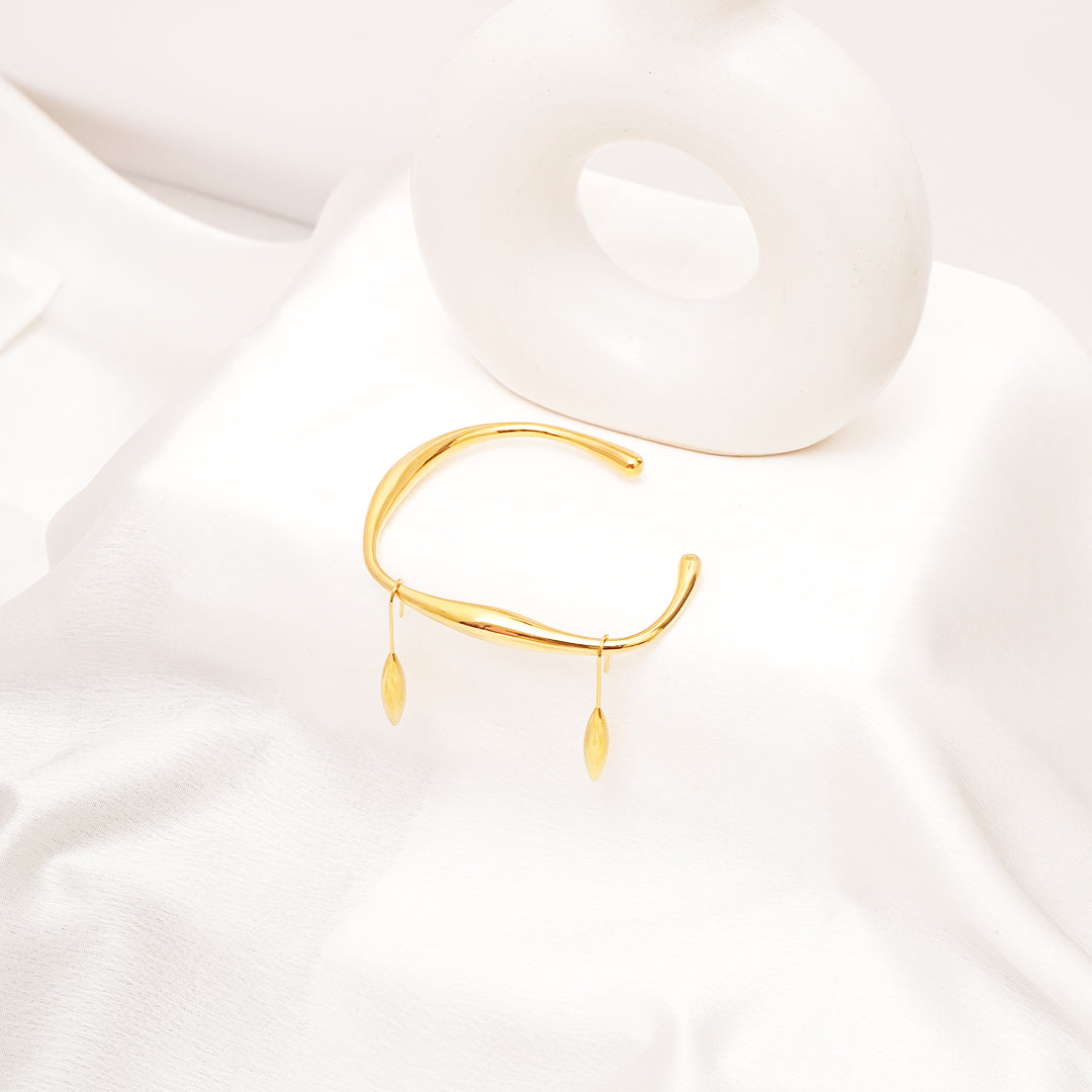Gold bracelet on a white fabric background