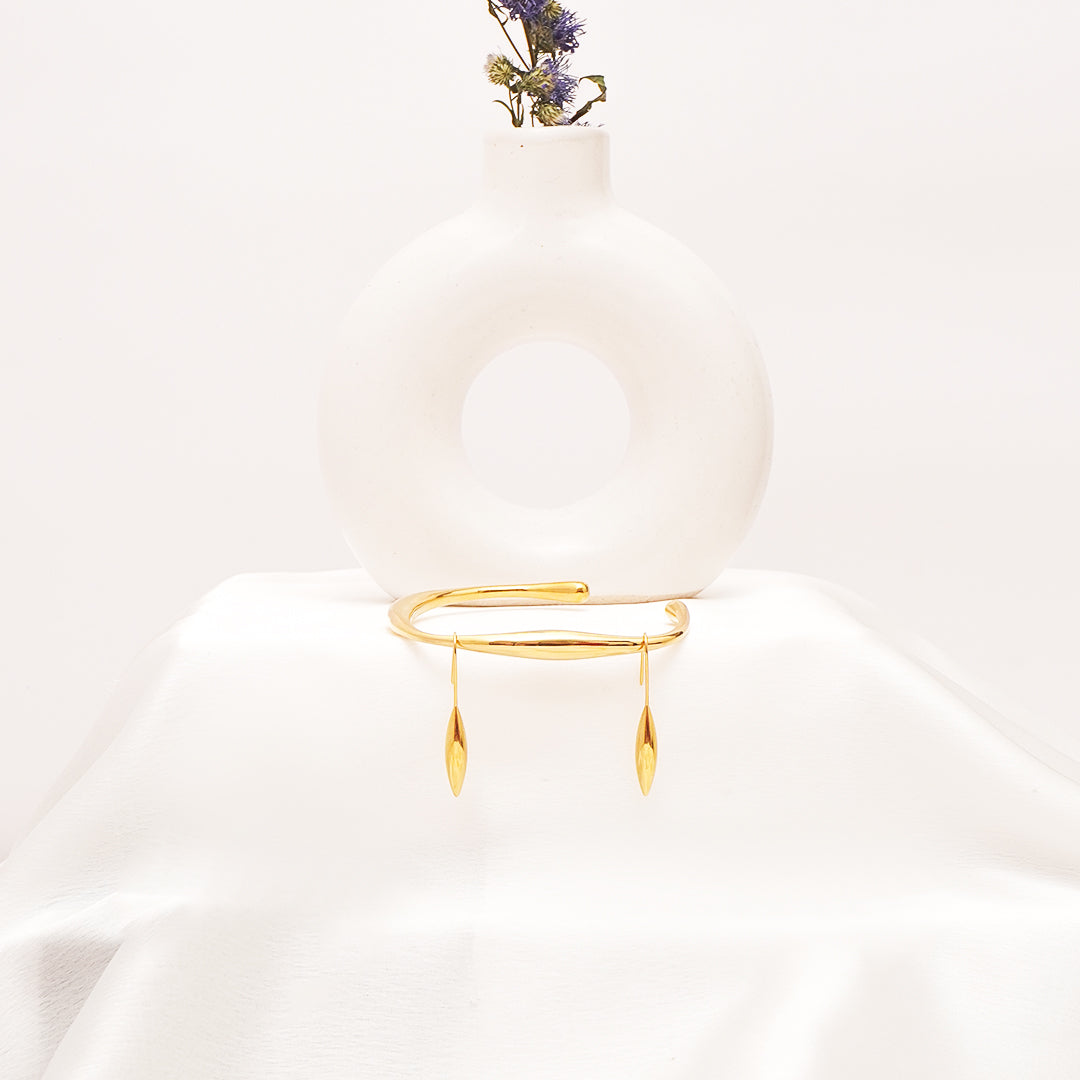 Gold bracelet on a mannequin with a white background