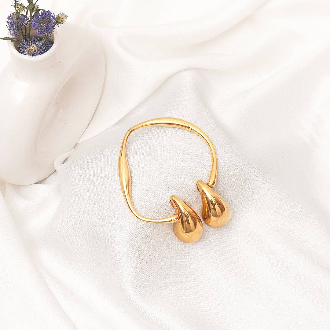 Gold hoop earrings on a white fabric background