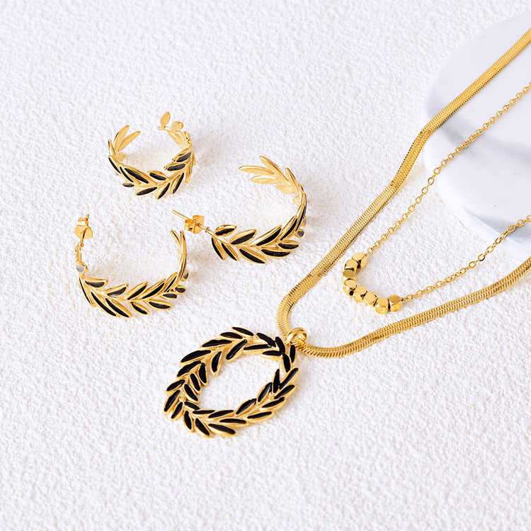 Gold jewelry set with necklace, earrings, and bracelet on a beige background