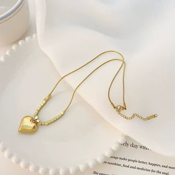 Gold necklace with a heart pendant on an open book with text