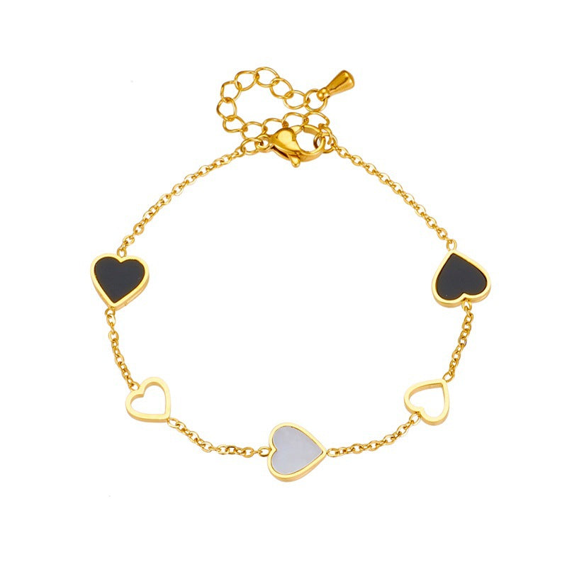 Gold bracelet with heart-shaped charms on a white background