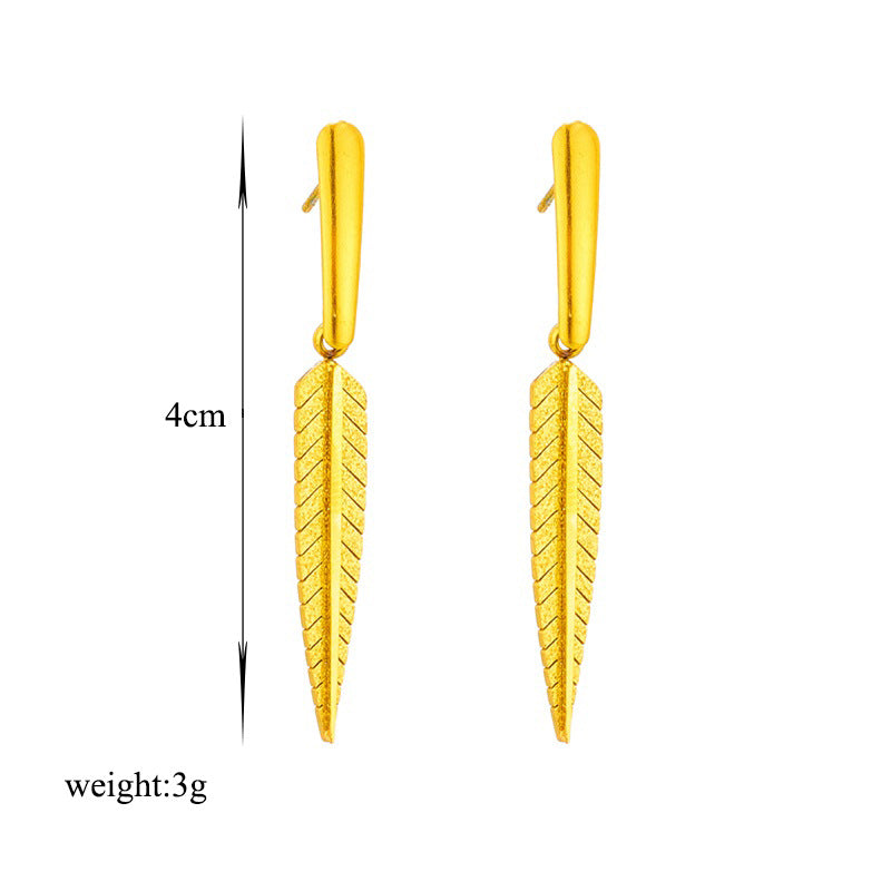 Gold leaf-shaped earrings with measurements on a white background