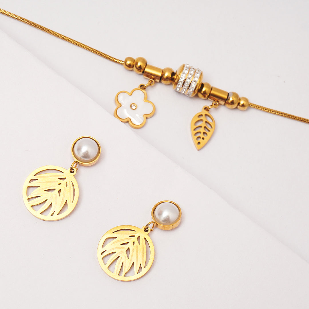 Gold bracelet with charms and earrings on a light gray background