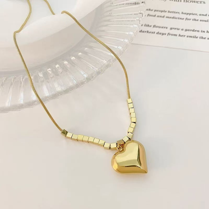 Gold heart-shaped pendant necklace on a white surface