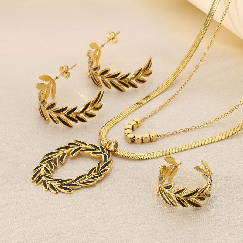 Gold jewelry set with necklace, earrings, and bracelet on a beige background