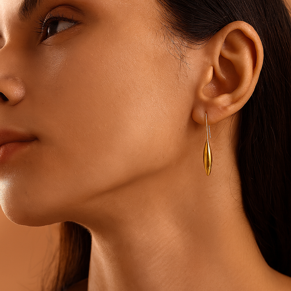 Close-up of a woman wearing a gold earring with a soft focus background