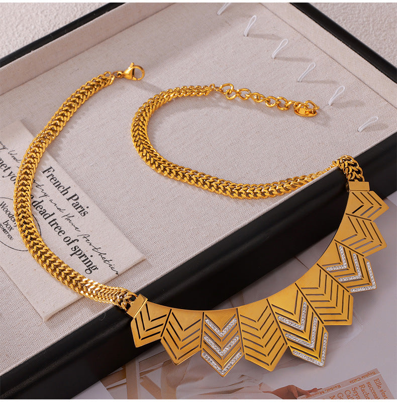 Gold necklace with geometric design on a textured surface