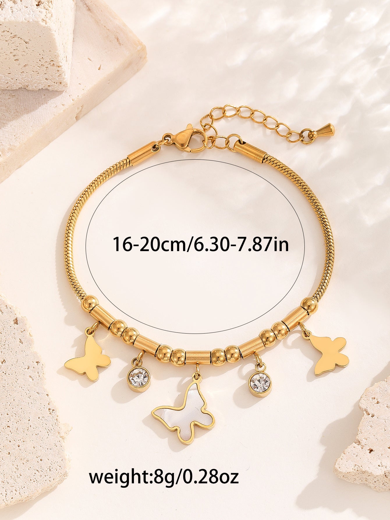 Gold bracelet with charms on a light background