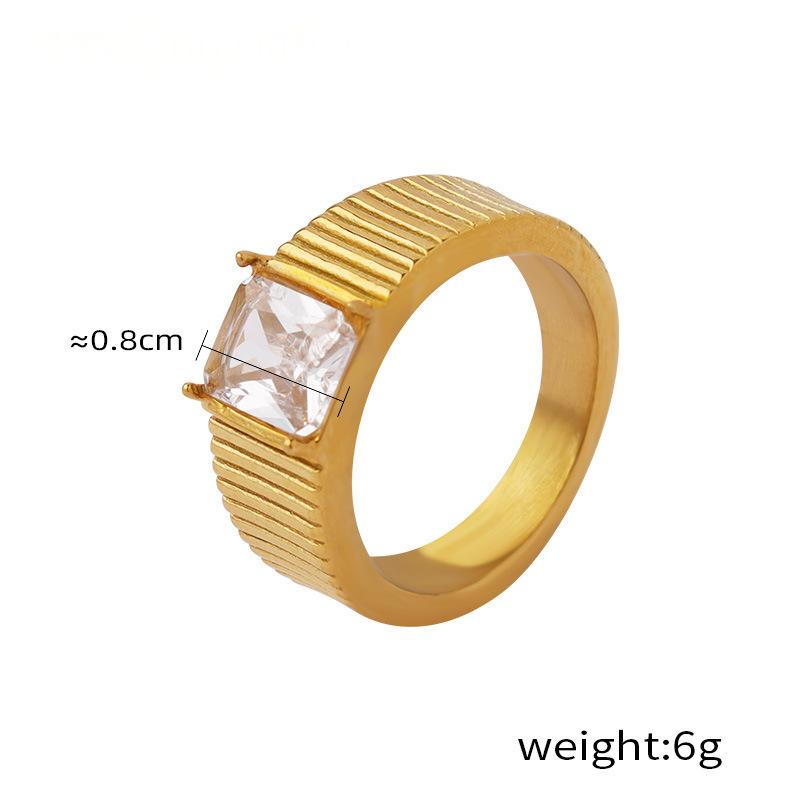 Gold ring with a clear gemstone on a white background