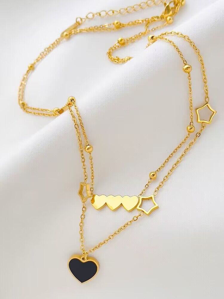 Gold necklaces with heart and star pendants on a white background