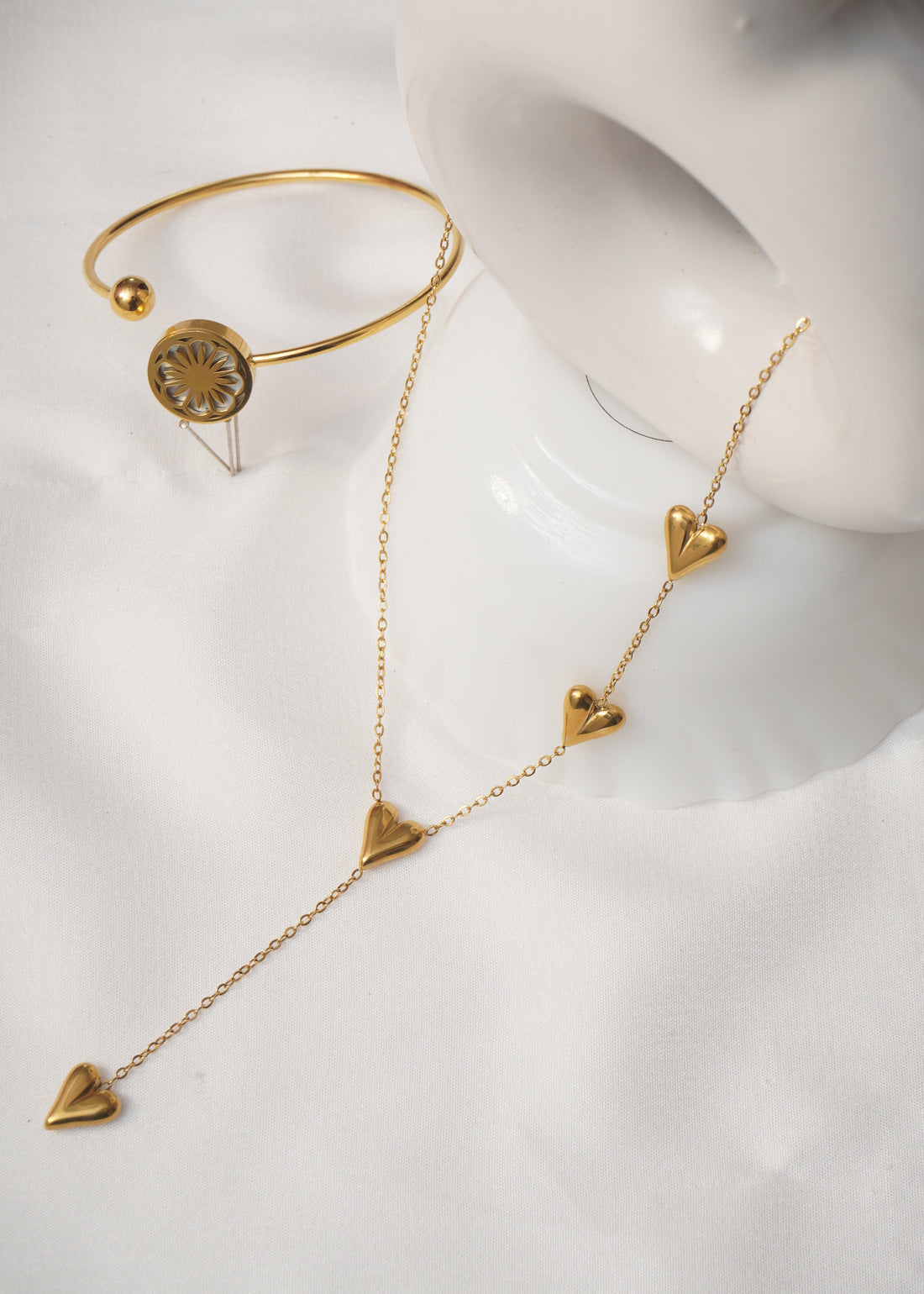 Gold jewelry set on a white mannequin bust