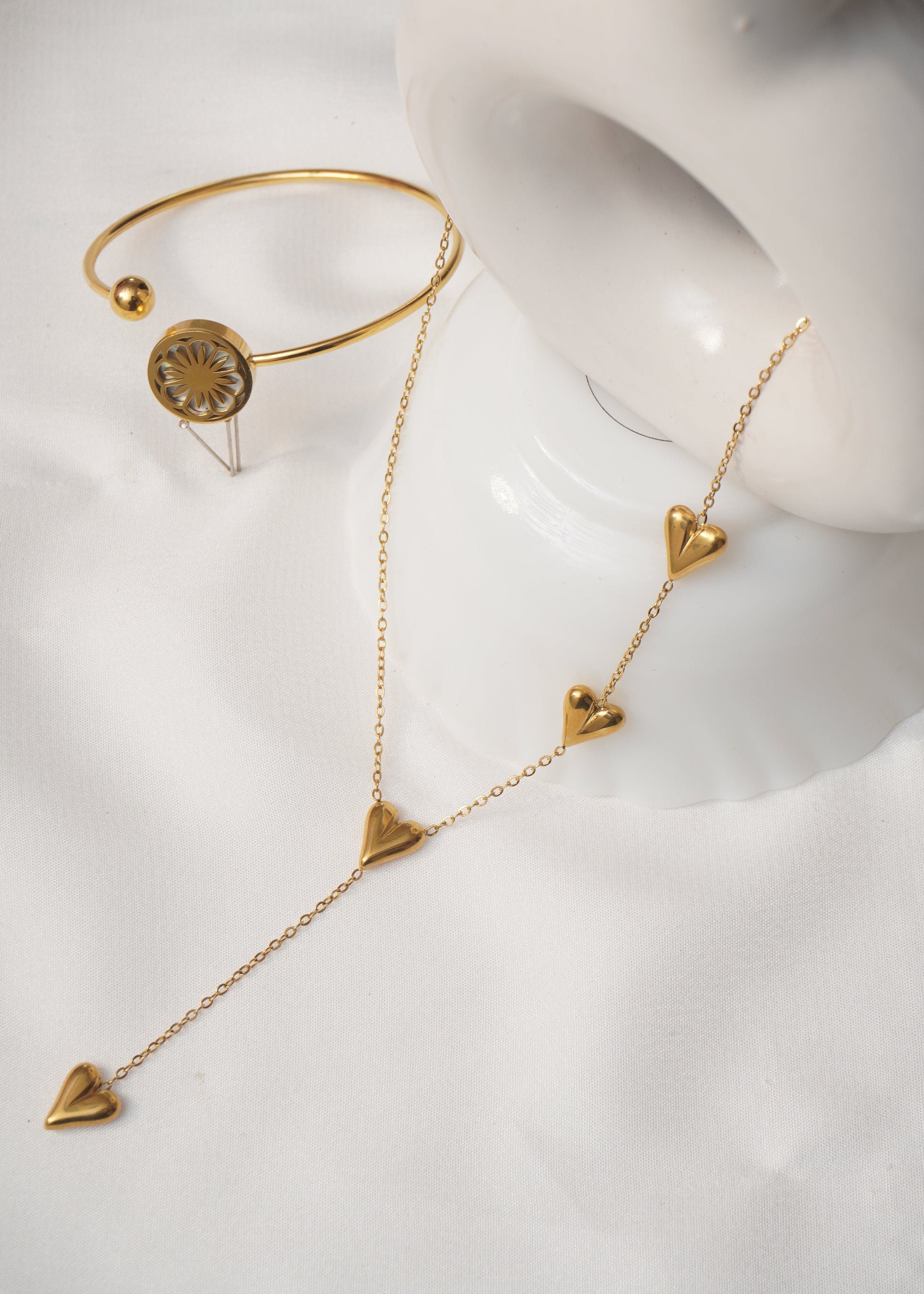 Gold jewelry set on a white mannequin bust