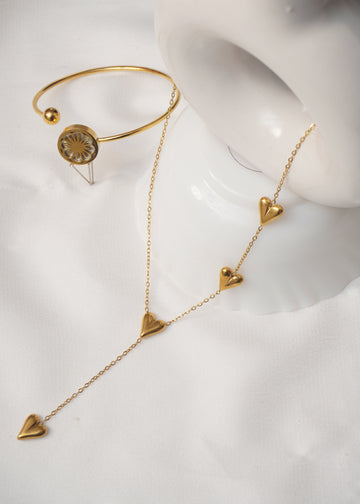 Gold jewelry set on a white mannequin bust