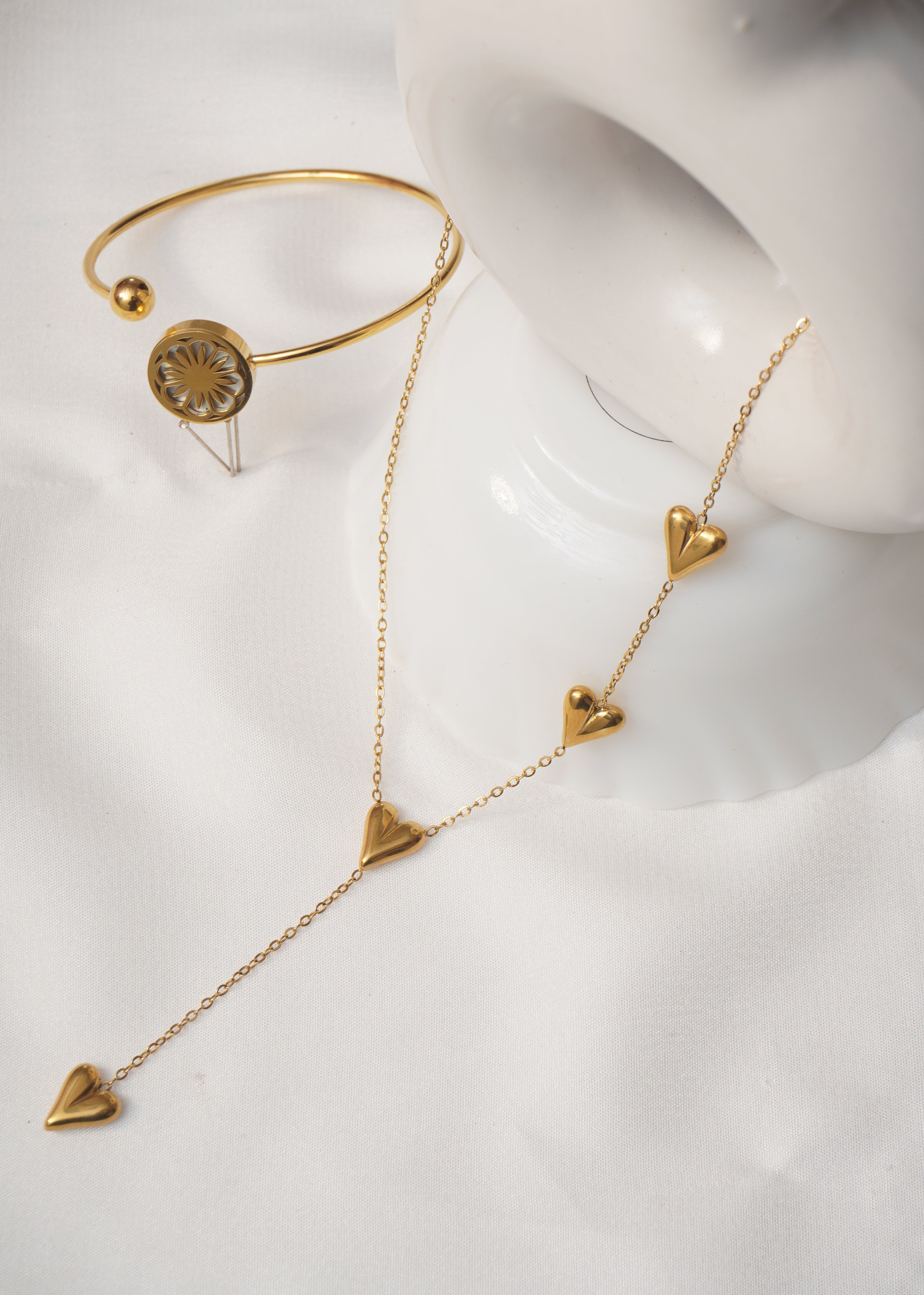Gold jewelry set on a white mannequin bust