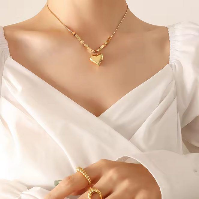 Gold necklace with a heart pendant on an open book with text
